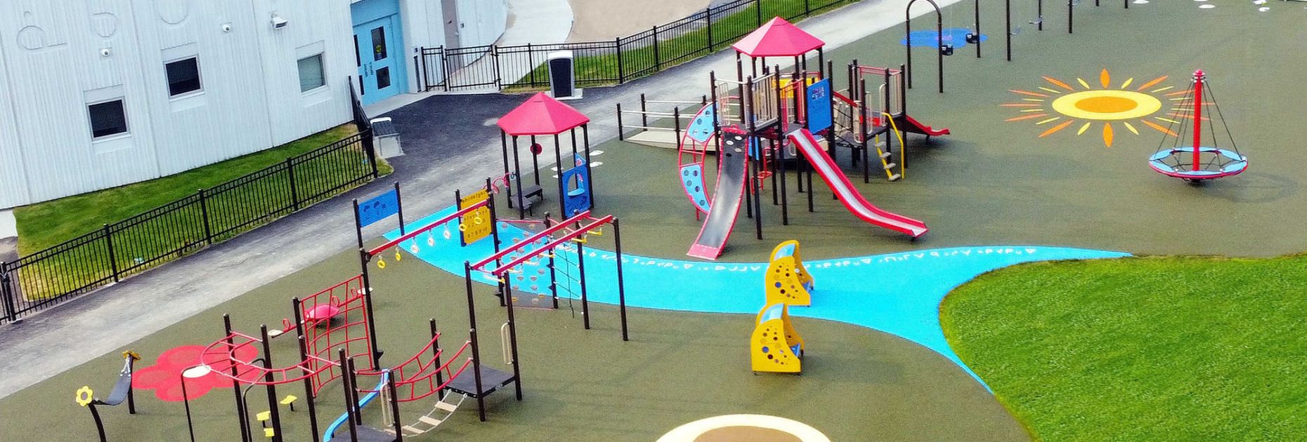 Large inclusive playground with stylized rubber surfacing at St Francis School in Saskatoon, Saskatchewan