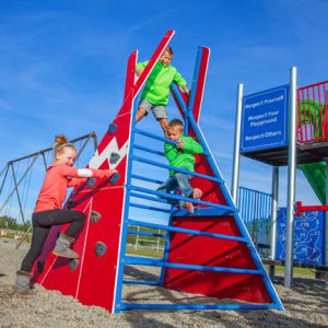 three kids climbing on a red, blue and white teepee-shaped Blue Imp Teepee Climber at a school playground in Red Deer, Alberta
