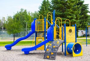 blue and yellow Blue Imp playground structure featuring slides, climbers and crawl tube