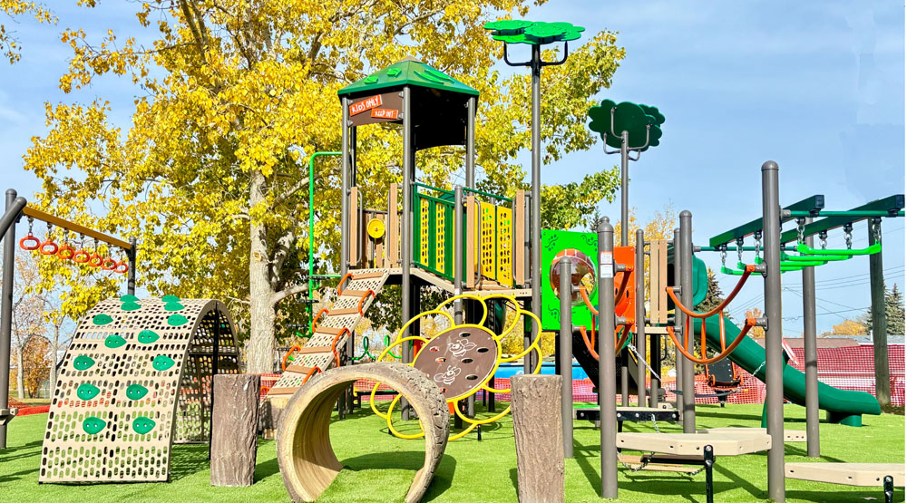 nature-themed commercial playground equipment Alberta with yellow leaves and blue sky in the background